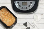 a bread maker next to fresh bread