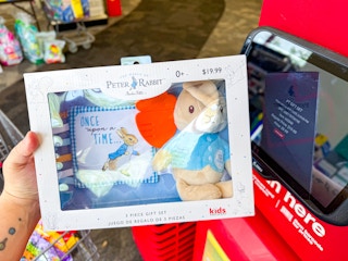 person holding a peter rabbit gift set by a scanner