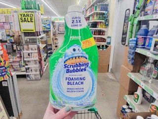 hand holding a bottle of scrubbing bubbles foaming bleach