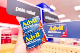 person holding 2 boxes of advil