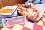 A pizza hut book it coupon next to a free personal pan pizza and a stack of books in a pizza hut restaurant