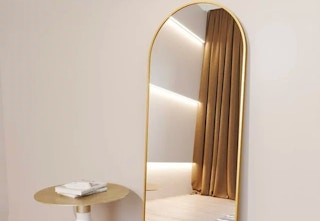 lifestyle image of gold arched mirror