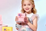 Girl holding a Kids Camera Instant Print Pink: HODDRCCN camera.