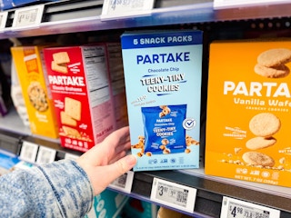 hand holding a box of partake teeny cookies on walmart shelf
