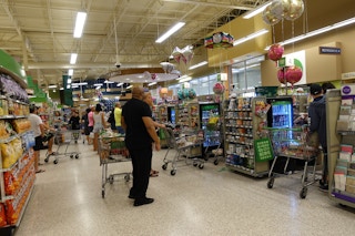 People standing in checkout lines at a Publix grocery store.