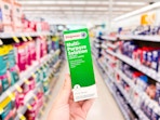 hand holding multipurpose contact lens solution in walgreens