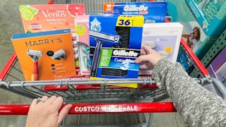 a person putting razors into a costco cart