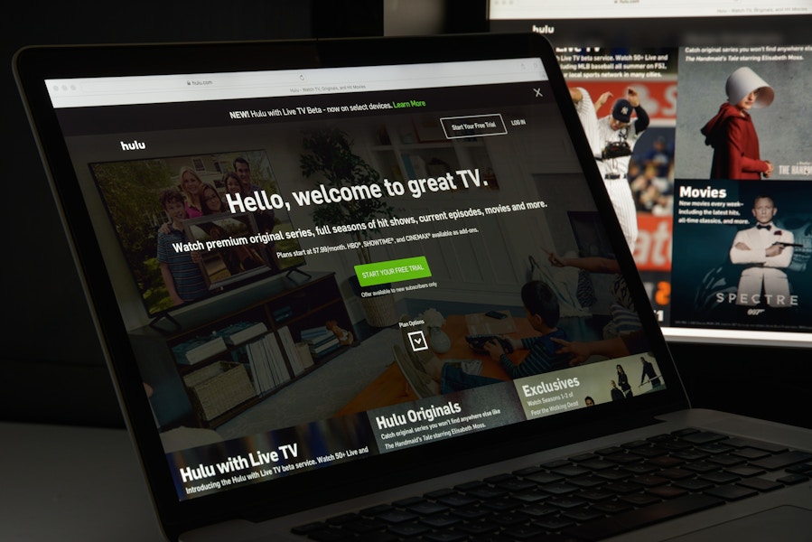 A computer and tv screen displaying Hulu's sign up portal