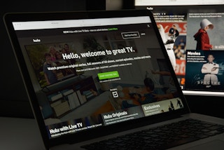 A computer and tv screen displaying Hulu's sign up portal