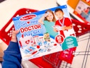 hand holding a melissa & doug get well kit over a target cart