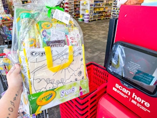 person holding a crayola tote bag gift set by the cvs scanner