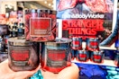 a person holding up three candles from the stranger things x bath and body collab 