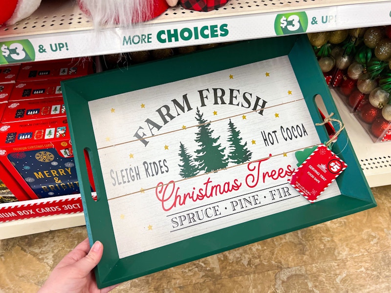 person grabbing a serving tray that has christmas trees on it and says farm fresh christmas trees