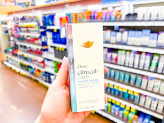a person holding deodorant in a store aisle