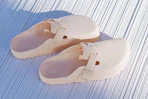 Stock image of a pair of light rose Birkenstock Adjustable Recovery Clogs