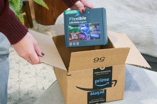 A person taking a box of flexible LED strip lights out of an Amazon box.