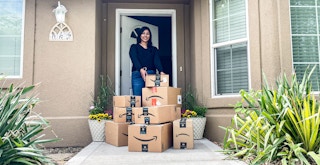 a person grabbing an amazon box on a front porch