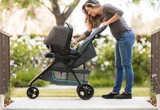 person pushing a the Baby Trend travel system outside