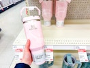 hand holding a stanley tumbler in front of a target shelf