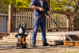 man using pressure washer on stairs