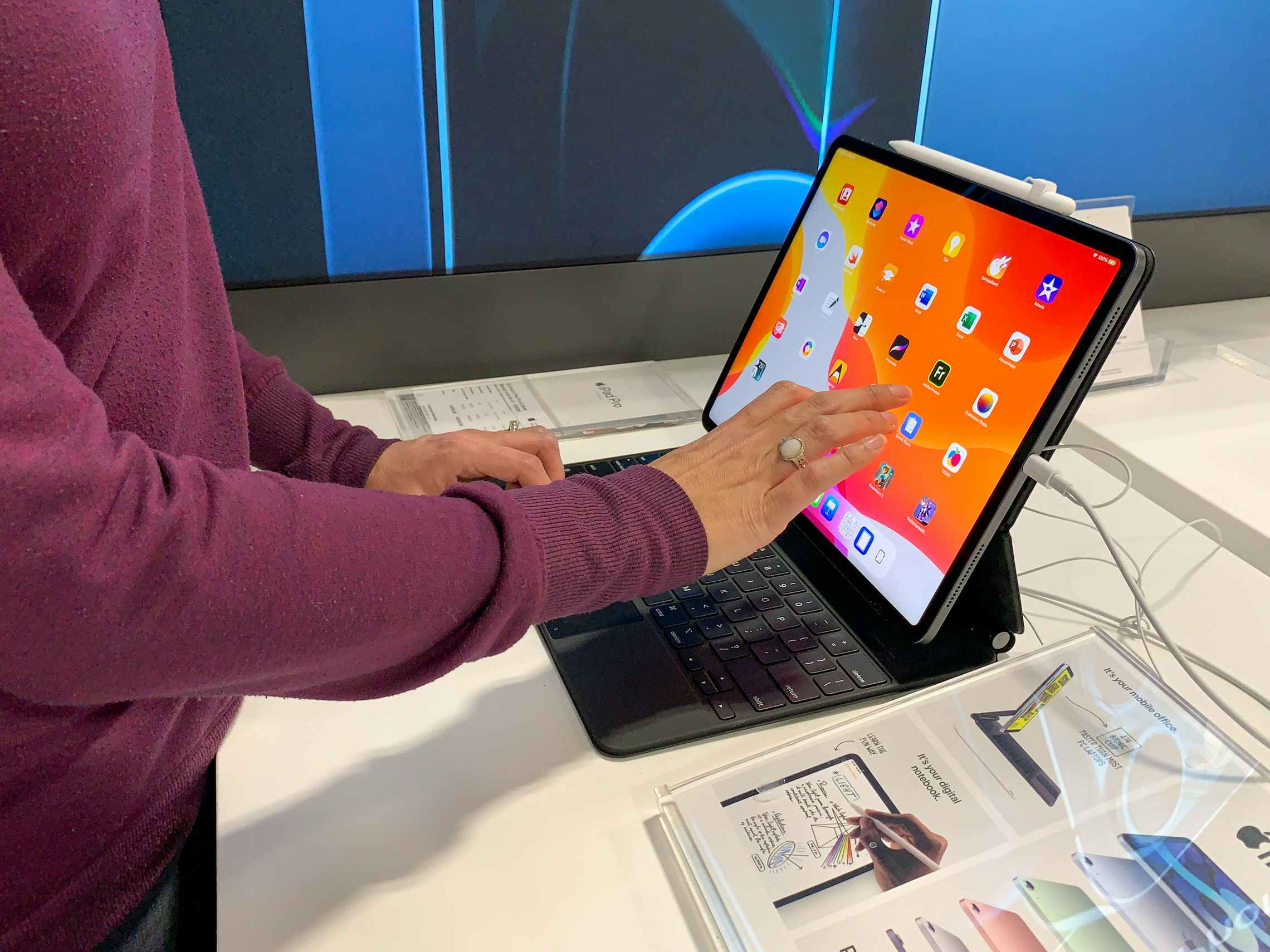 A woman inside Best Buy looking at an apple ipad on display.