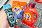 person placing downy unstoppables into a cart with tide pods and laundry detergent in it