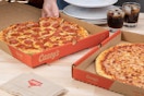 Someone taking a slice of pizza from a Casey's box