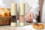 a salt and pepper grinder near spaghetti