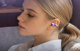 a person wearing metallic purple clip-on earbuds