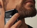 a man using a shaver on their beard