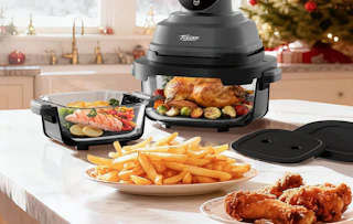 a portable air fryer on a counter with a plate of food