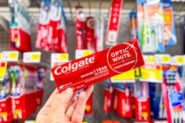 hand holding up colgate optic white toothpaste