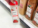 hand holding a suave body wash in front of a target shelf