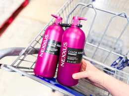 hand placing bottle of nexxus hair care in sams club shopping cart