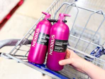 hand placing bottle of nexxus hair care in sams club shopping cart
