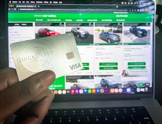 Hand holding a capital one credit card