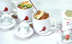 mugs with food inside next to a lid with a snow globe