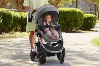 Woman pushing her child in the Graco Modes Pramette Travel System, 3-in1 Modular Carseat Stroller Combo.