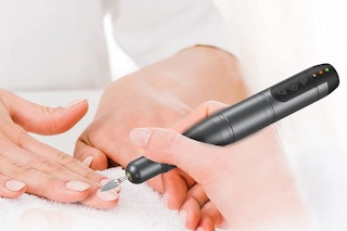 An electric nail file being used on a person's nails