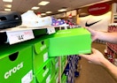 Man pulling Crocs shoe box off the shelf