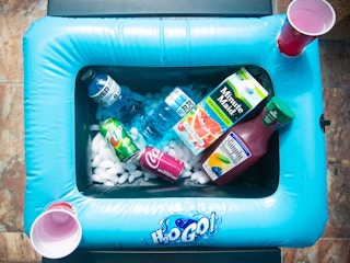 Blue pool raft with assorted drinks with two red cups