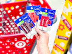 hand holding 3 nivea lip packs in front of a target cart