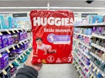 hand holding huggies diaper bag in walgreens