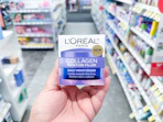 hand holding loreal collagen moisturizer in walgreens
