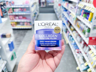 hand holding loreal collagen moisturizer in walgreens