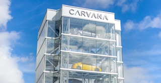 The sign on a Carvana vending machine building with vehicles inside