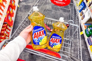 person placing ajax dish soap in a cart