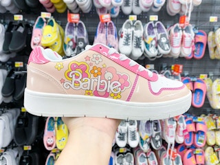 hand holding a Barbie sneaker
