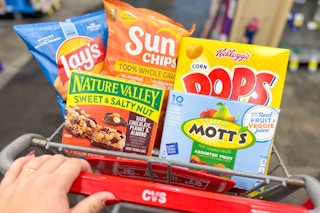 hand pushing a cvs shopping cart with snacks