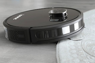 lifestyle image of a robot vacuum cleaning a rug
